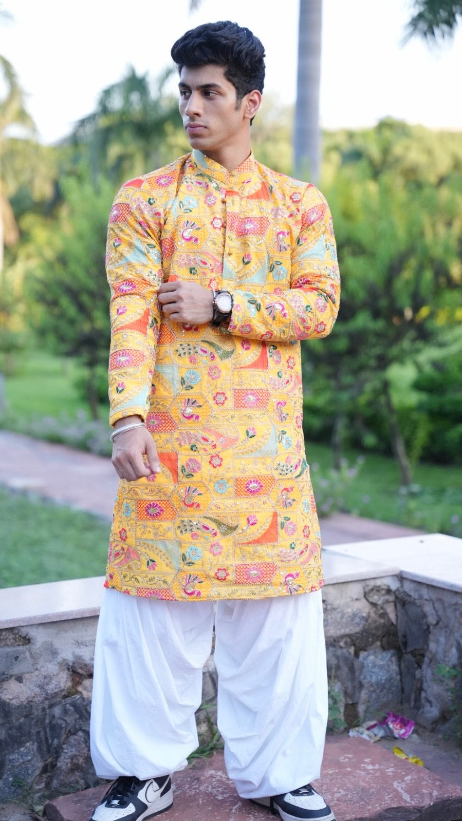 Men’s bright yellow Suryansh kurta with vibrant traditional print and white salwar, ethnic festive wear photoshoot outdoors